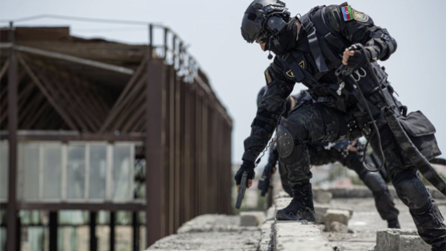 Silahlı cinayətkar saxlanılarkən ailə üzvlərini önə verərək polis əməkdaşlarını qətlə yetirdi